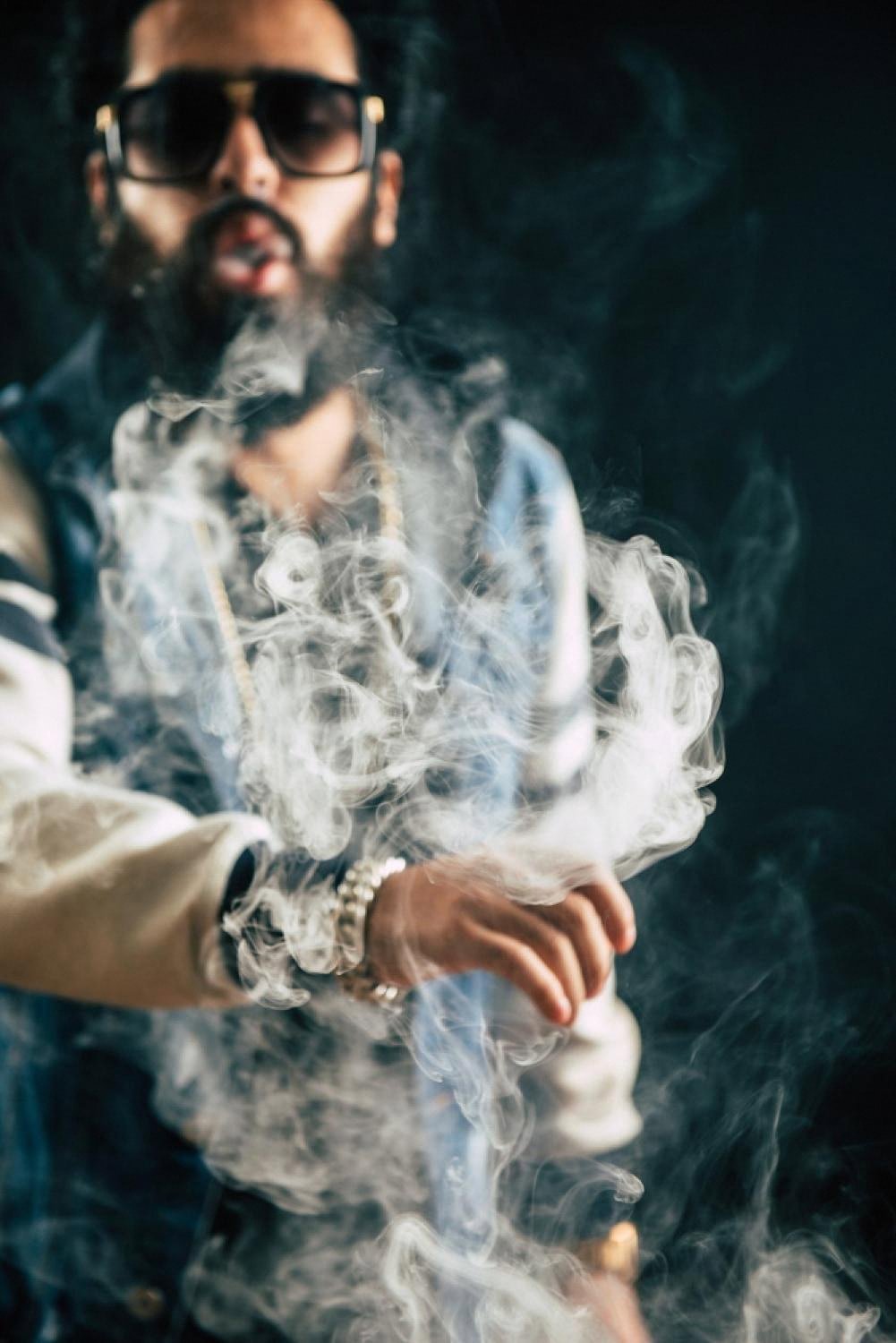 Adult vaper in sunglasses exhaling vapour, lifestyle shot for UAE buyer's guide